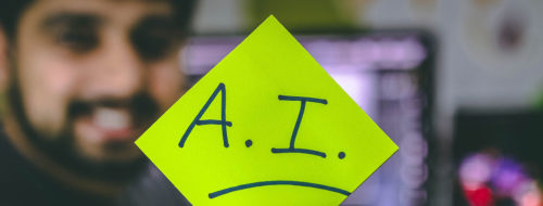 Man holding a Post It with the capital Letters A.I. / Photo by Hitesh Choudhary on Unsplash